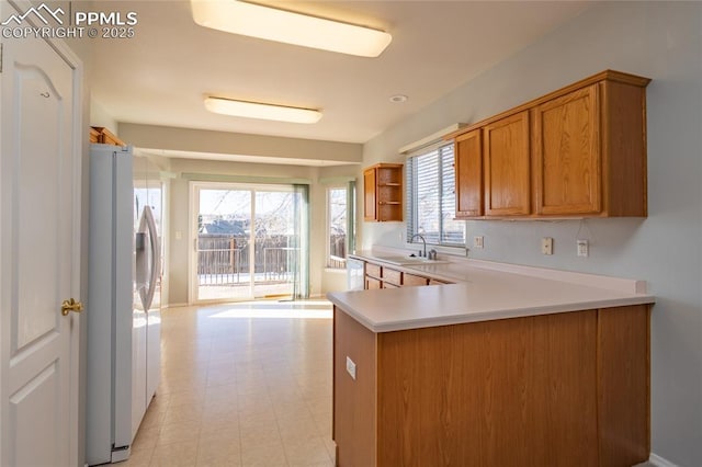 kitchen featuring white appliances, kitchen peninsula, and sink