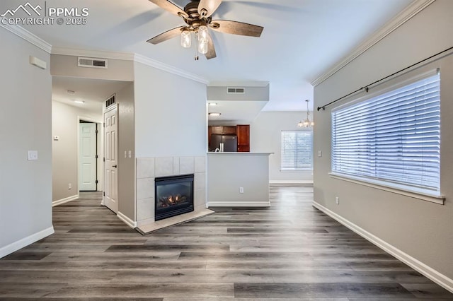 unfurnished living room featuring a tile fireplace, crown molding, and dark hardwood / wood-style flooring