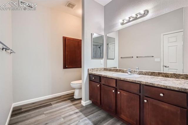 bathroom with vanity, hardwood / wood-style flooring, and toilet