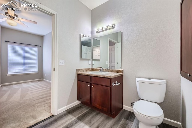 bathroom featuring hardwood / wood-style flooring, vanity, ceiling fan, and toilet