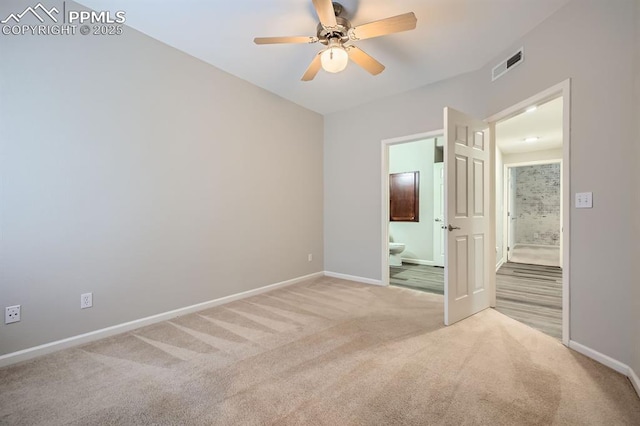 unfurnished bedroom featuring ceiling fan, light colored carpet, and ensuite bathroom