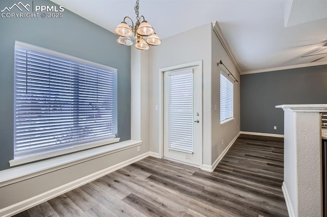 entryway featuring hardwood / wood-style flooring, ornamental molding, and a chandelier