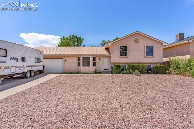 split level home featuring a garage and central AC unit