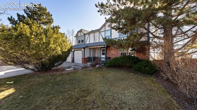 back of property featuring brick siding, stucco siding, concrete driveway, a lawn, and a garage