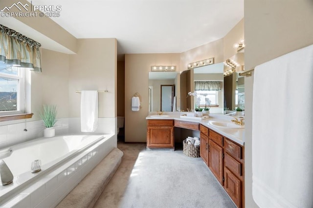 bathroom with a garden tub and vanity