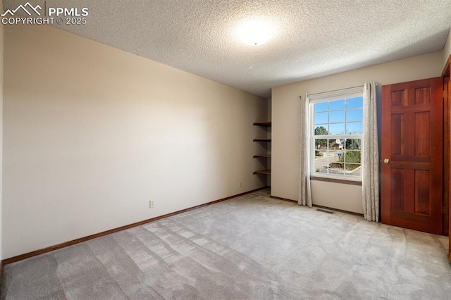 unfurnished bedroom featuring light carpet, a textured ceiling, visible vents, and baseboards