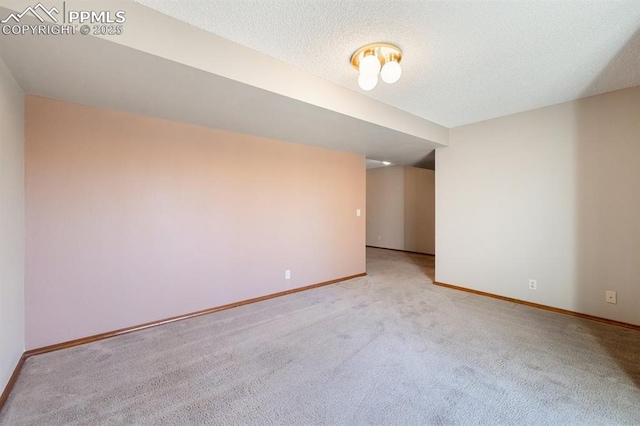 unfurnished room featuring light carpet, a textured ceiling, and baseboards