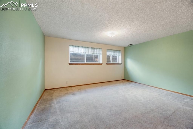 carpeted empty room featuring baseboards and a textured ceiling