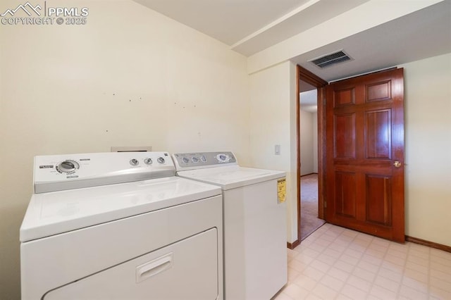 clothes washing area featuring laundry area, baseboards, visible vents, and washing machine and clothes dryer