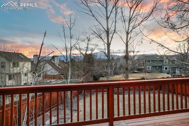 deck at dusk featuring a residential view