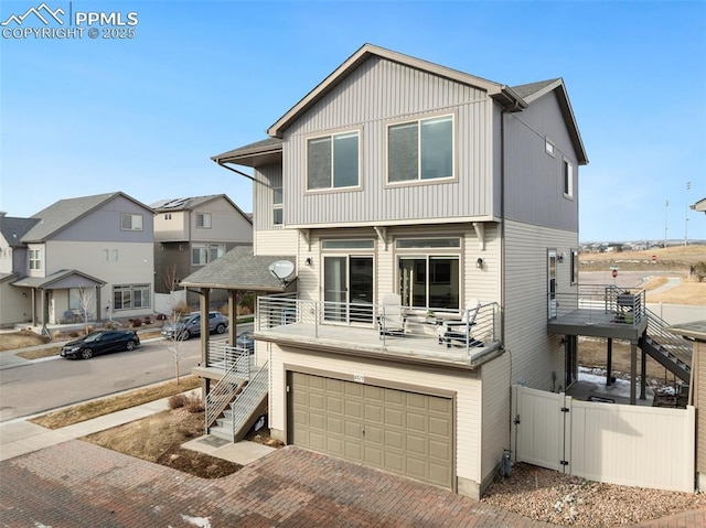 view of front facade featuring a garage, stairway, decorative driveway, and a balcony