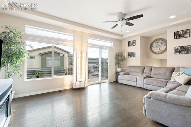 living room featuring recessed lighting, dark wood-type flooring, visible vents, a ceiling fan, and baseboards