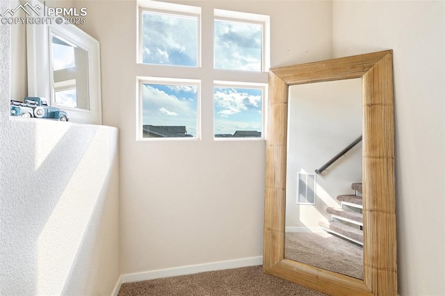 doorway to outside featuring carpet floors, plenty of natural light, visible vents, and baseboards