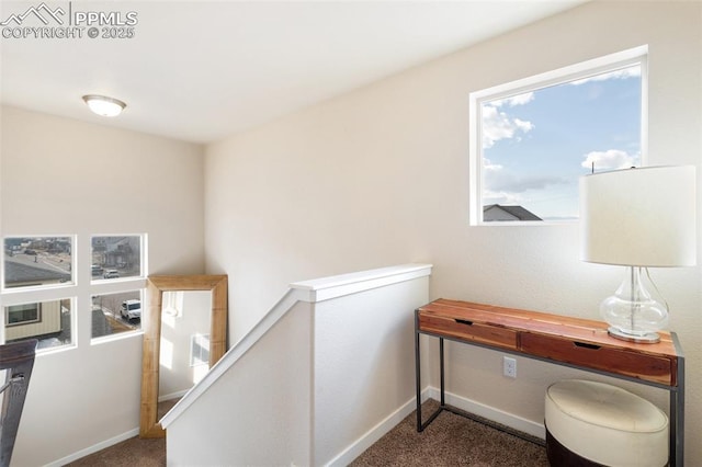 interior space with carpet, an upstairs landing, and baseboards