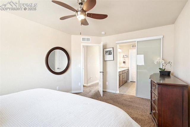 bedroom featuring baseboards, visible vents, ensuite bathroom, and light colored carpet