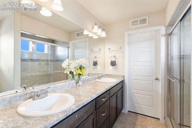 bathroom with a sink, visible vents, and a shower stall