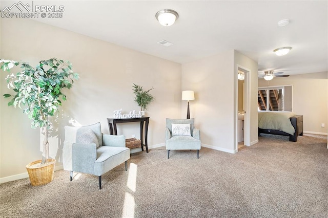 sitting room with carpet floors, a ceiling fan, visible vents, and baseboards