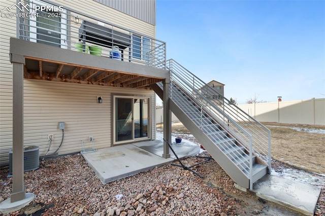 back of house with stairway, a patio, fence, and central air condition unit