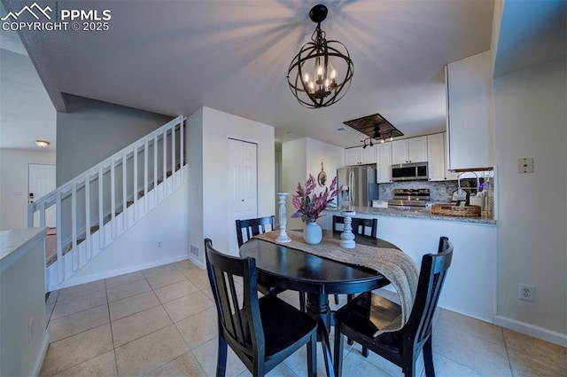 tiled dining room featuring a chandelier