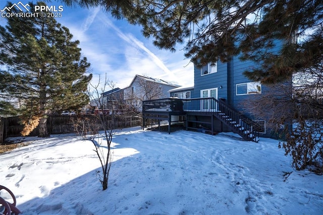 yard layered in snow featuring a wooden deck