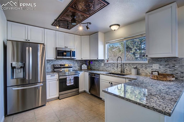 kitchen featuring light stone counters, appliances with stainless steel finishes, sink, and white cabinets