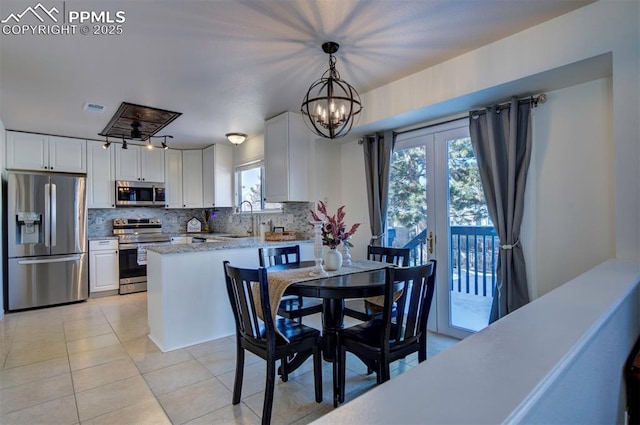 dining area featuring sink, light tile patterned floors, and a notable chandelier