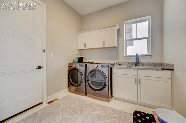 clothes washing area featuring cabinets, separate washer and dryer, sink, and light tile patterned floors