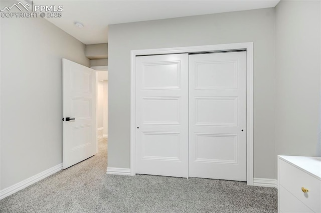 unfurnished bedroom with a closet and light carpet