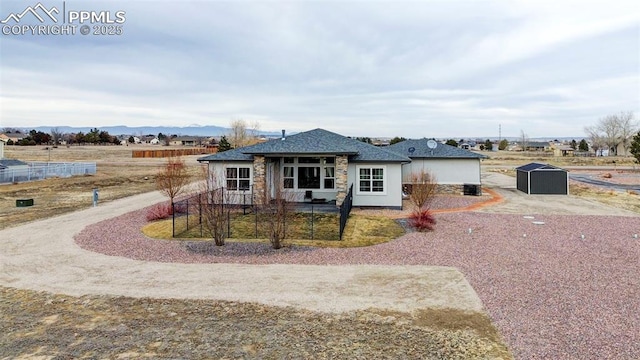 ranch-style home featuring a storage shed and a mountain view