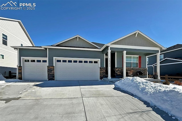 craftsman inspired home featuring a garage, stone siding, driveway, and a porch