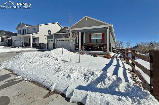 view of front of home with a porch, an attached garage, and fence