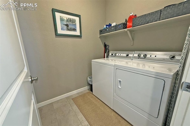 laundry room with laundry area, independent washer and dryer, light tile patterned flooring, and baseboards