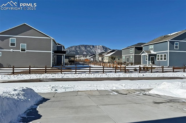 exterior space with a residential view, fence, and a mountain view