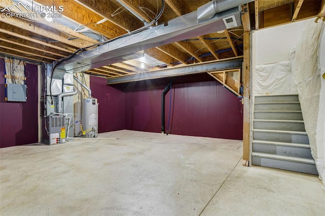 basement featuring electric panel, heating unit, and gas water heater