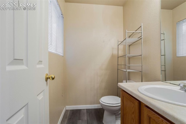 bathroom with hardwood / wood-style flooring, vanity, and toilet