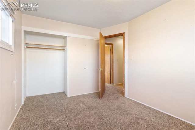 unfurnished bedroom featuring carpet floors and a closet