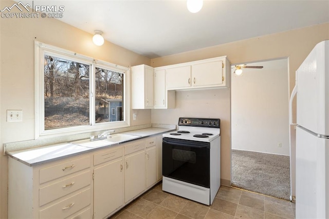 kitchen with sink, light carpet, white fridge, electric stove, and white cabinets