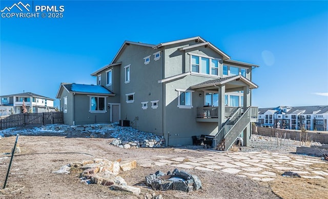 back of property featuring cooling unit and an outdoor fire pit