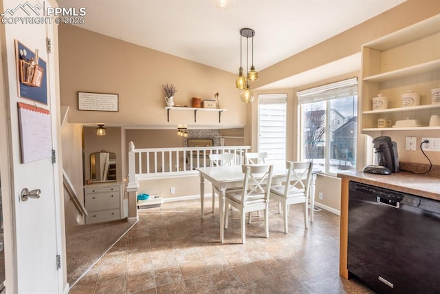 dining room featuring lofted ceiling and a fireplace