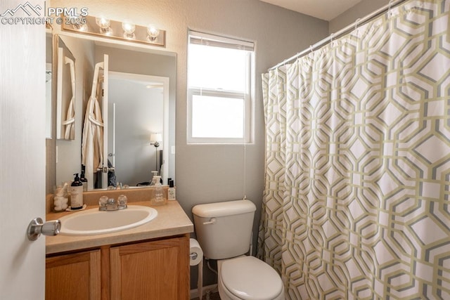 bathroom featuring vanity, a shower with shower curtain, and toilet