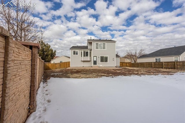 view of snow covered rear of property