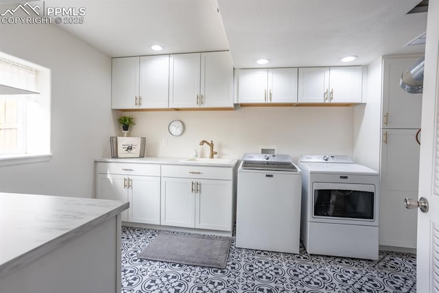 washroom with cabinets, independent washer and dryer, sink, and light tile patterned floors