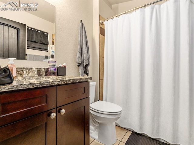 bathroom featuring vanity, toilet, and tile patterned flooring