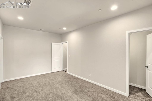 carpeted empty room featuring baseboards and recessed lighting