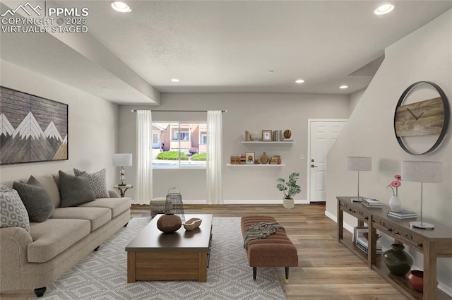 living area with recessed lighting, baseboards, and wood finished floors