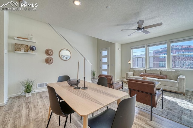 dining space featuring ceiling fan, a textured ceiling, and light hardwood / wood-style flooring