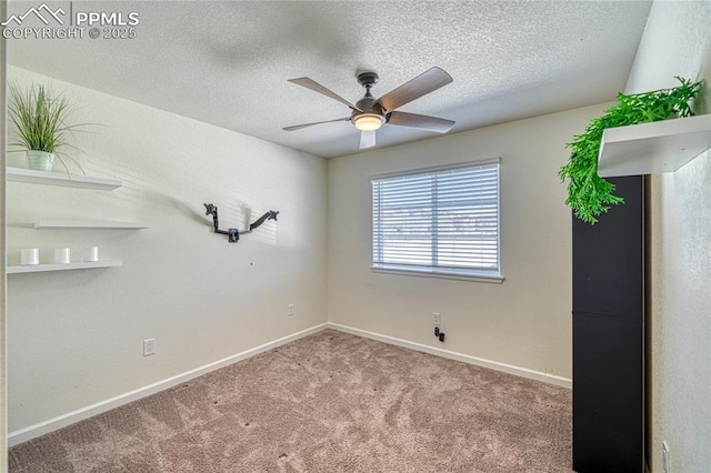 carpeted empty room with ceiling fan and a textured ceiling