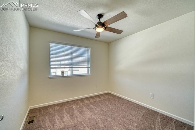 carpeted spare room with ceiling fan and a textured ceiling