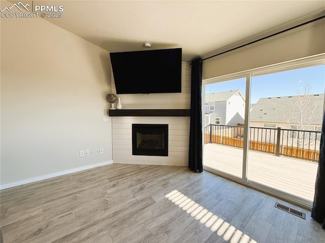 unfurnished living room with a fireplace and light hardwood / wood-style flooring