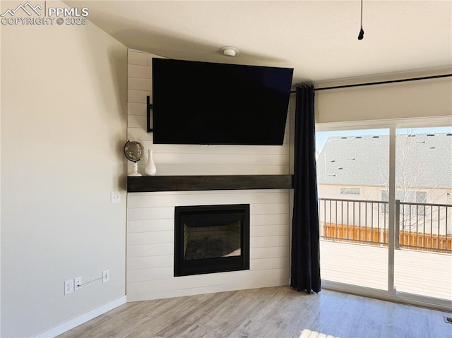 unfurnished living room featuring a fireplace and light hardwood / wood-style floors